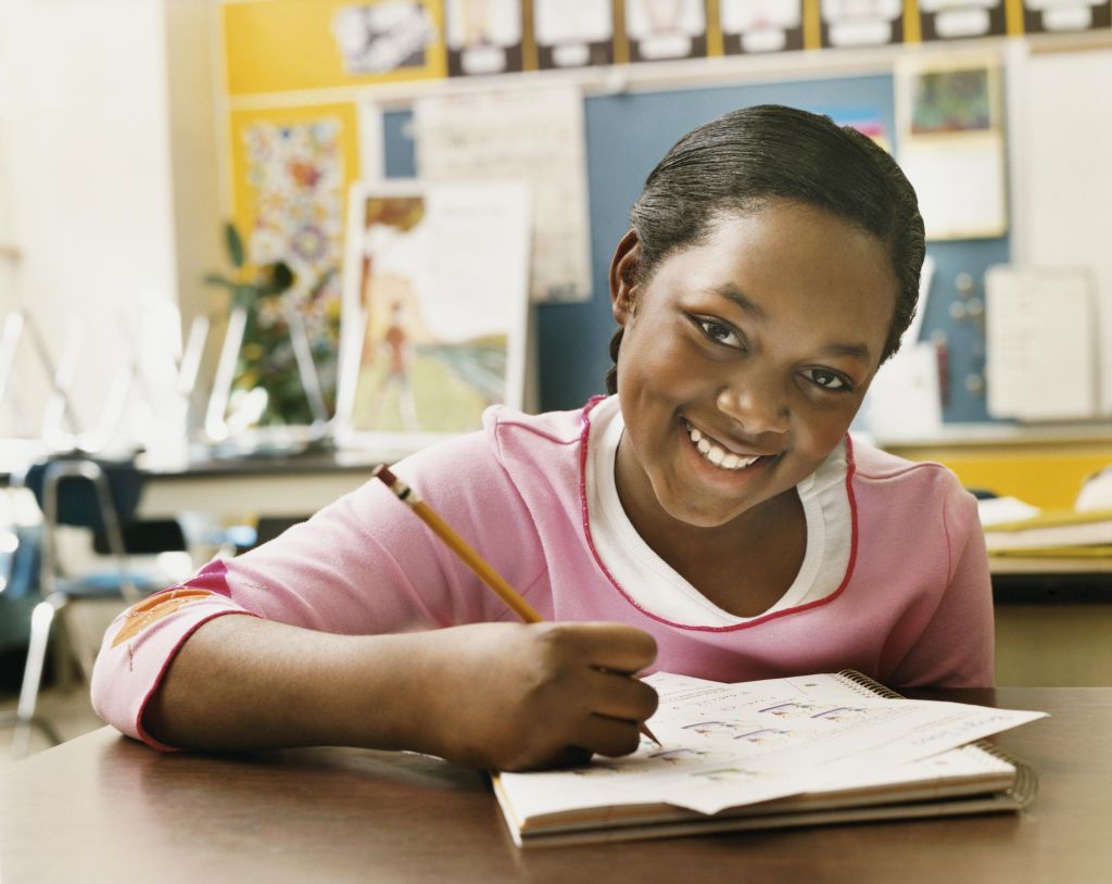 Portrait of a Schoolgirl Writing in Her Exercise Book in a Classroom