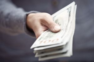 Hand of man holding stack of US dollars