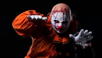 Creepy Halloween Clown in Bloody Mask, Portrait on Black