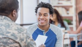 Smiling young man talks with military officer