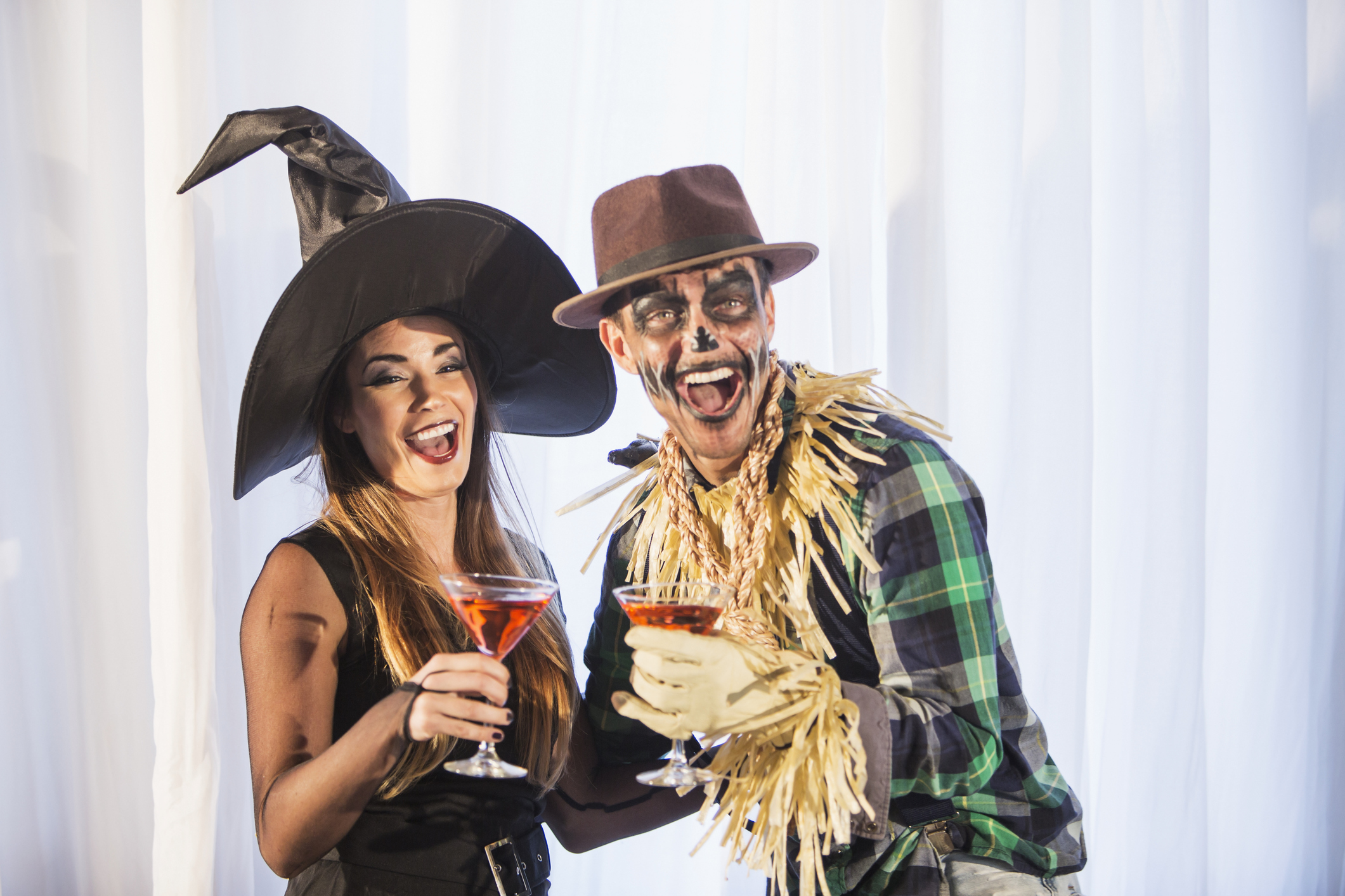 Witch and scarecrow at adult halloween party