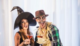 Witch and scarecrow at adult halloween party