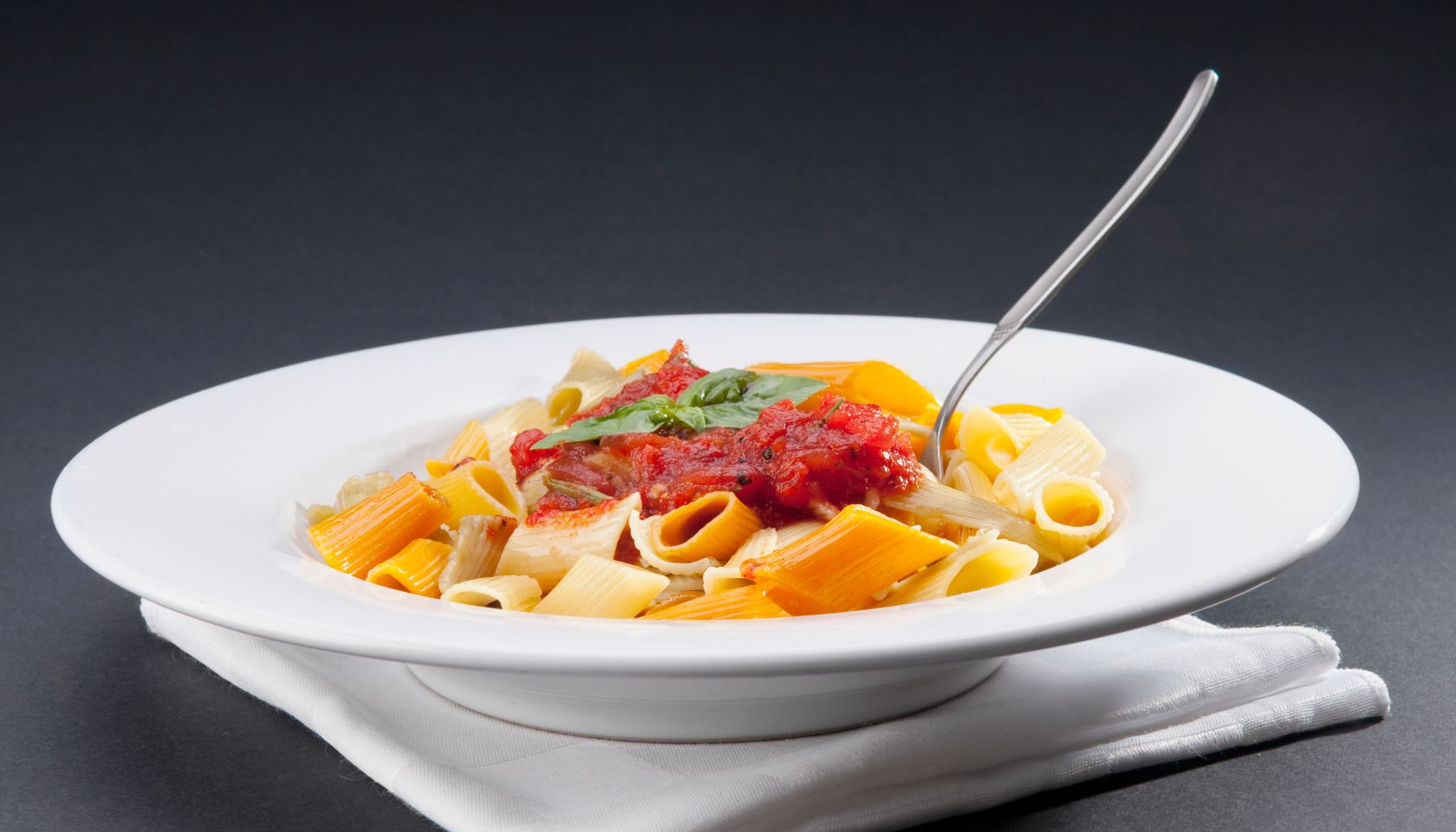 Dish of rigatoni pasta topped with tomato concasse