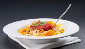 Dish of rigatoni pasta topped with tomato concasse