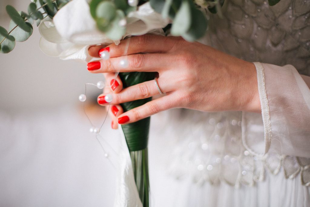 Bride holding wedding bouquet with wedding ring on her hand