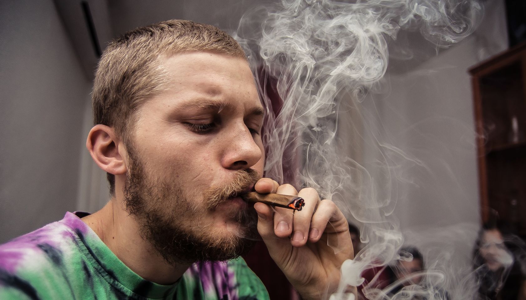 Close-Up Of Young Man Smoking Marijuana Joint