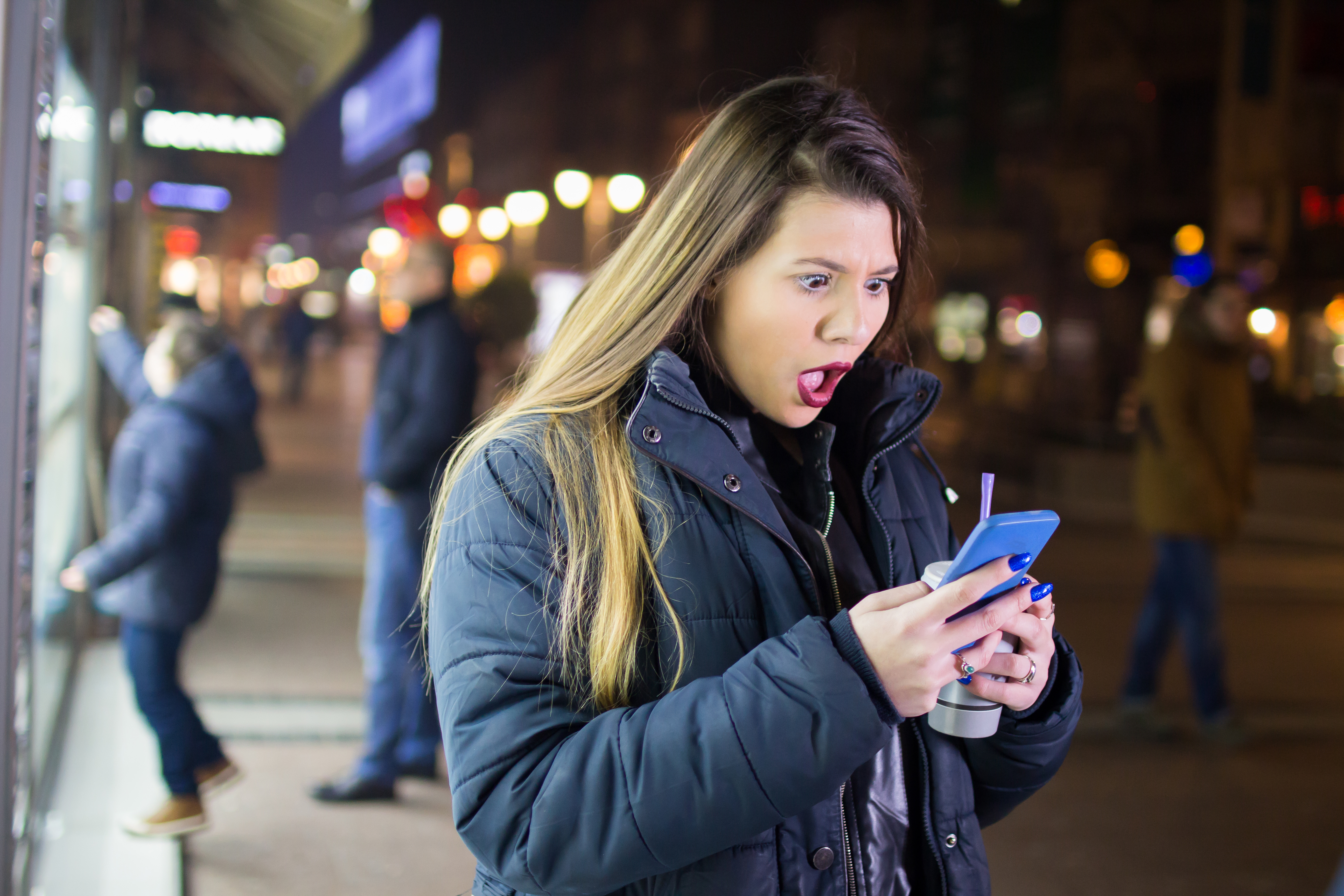 Girl downtown at night using phone