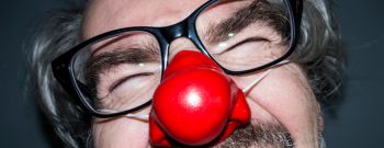 Laughing man wearing a red nose