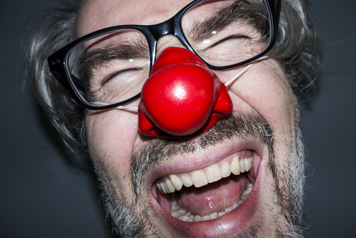 Laughing man wearing a red nose