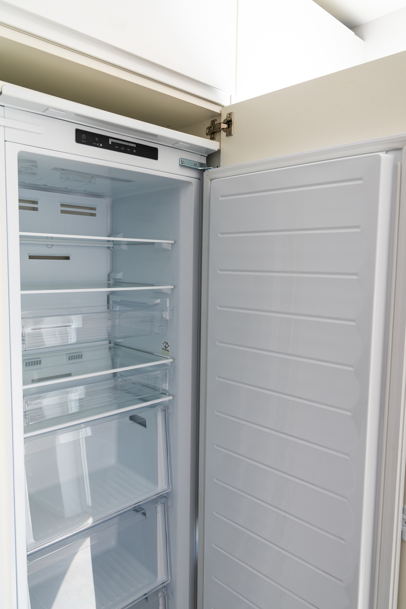 Modern upright freezer with open door and clean interior shelves