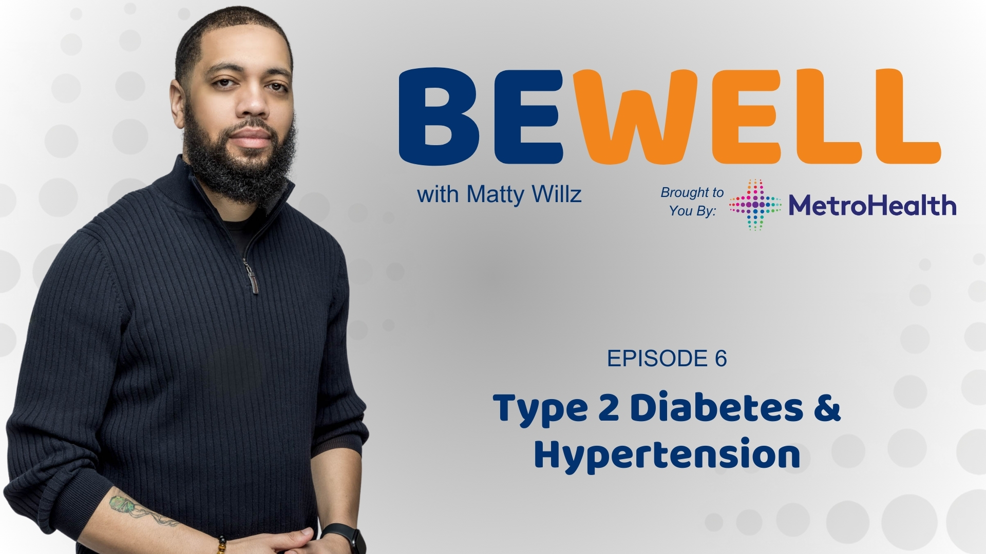 A man with a beard wearing a black sweater standing in front of a "Be Well with Matty Willz" banner, brought to you by MetroHealth.