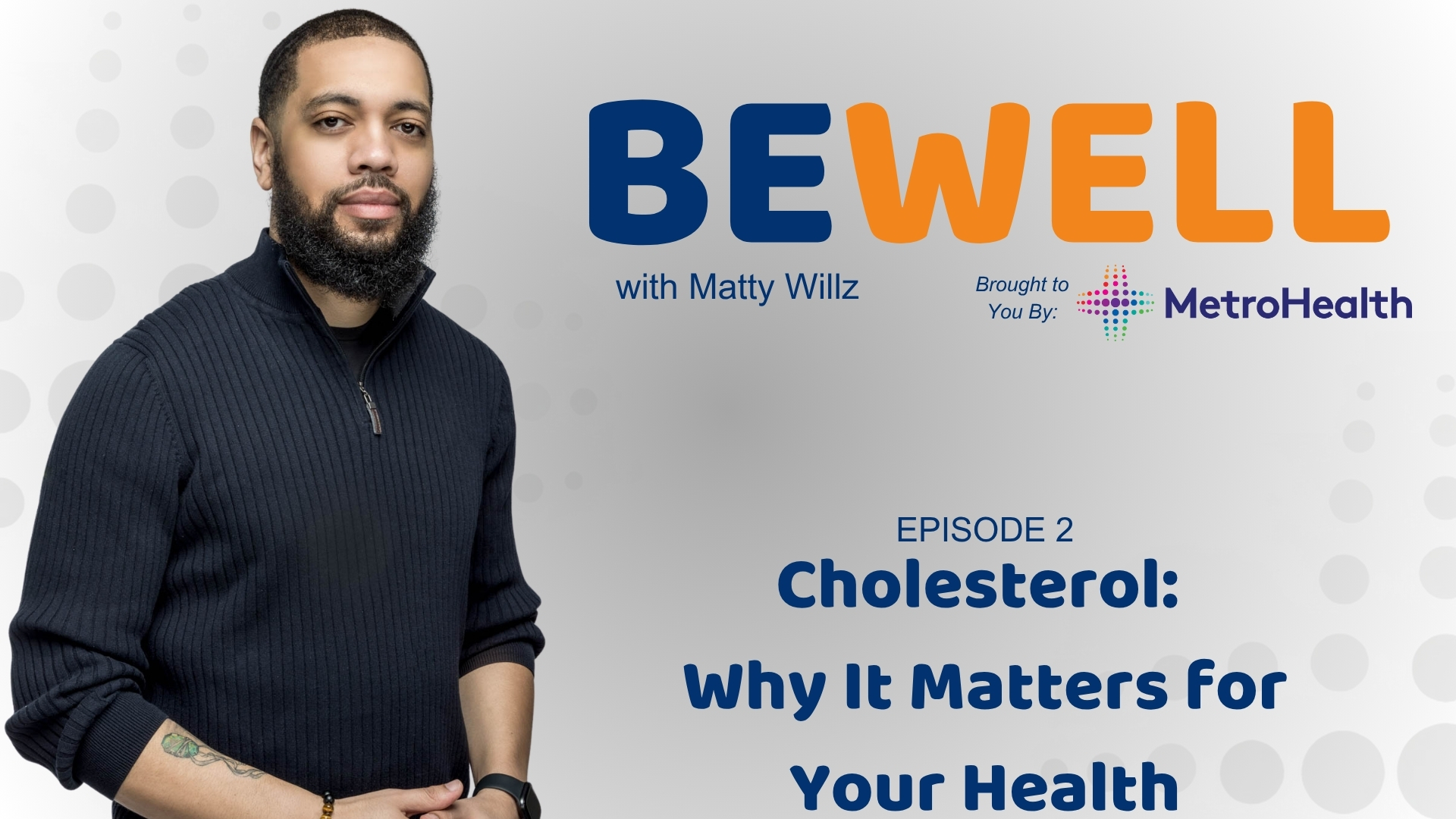 A man with a beard wearing a black sweater stands in front of a "Be Well with Matty Willz" backdrop, brought to you by MetroHealth.